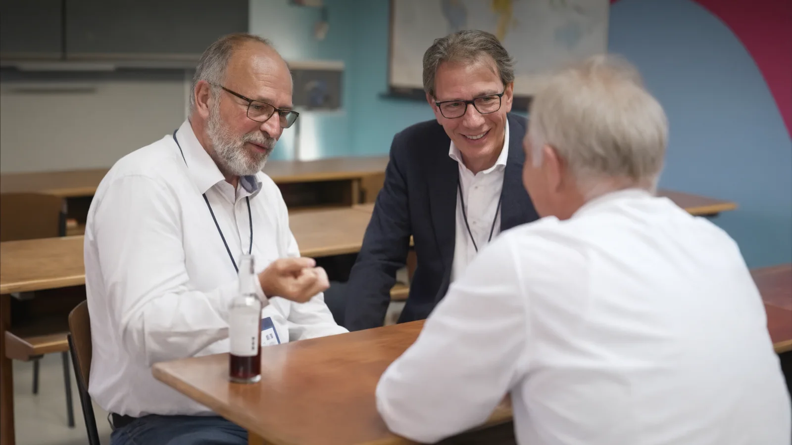 Klaus Stenzel und Thorsten Kramer im Gespräch mit einem Gesprächspartner an einem Tisch